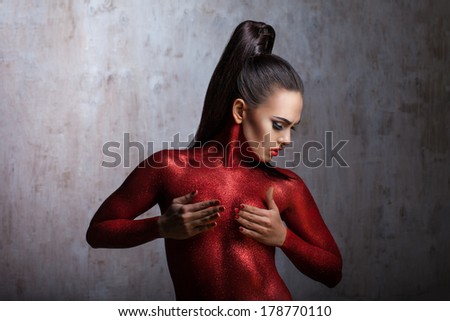 girl covered in red body, puts his hand over his chest