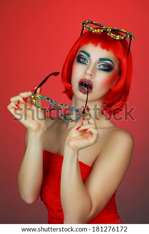 beautiful girl in a red wig and bright makeup, fashion glasses decorated