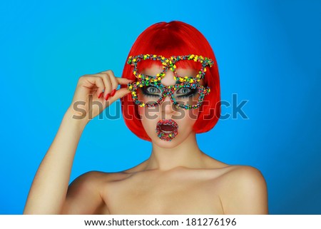 beautiful girl in a red wig and bright makeup, fashion glasses decorated