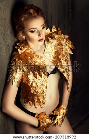 red-haired woman in a gold suit