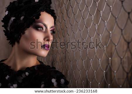 beautiful woman with bright make-up near the grid