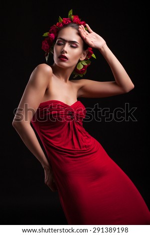 young woman in a red dress with flowers on the head, shot on a black background