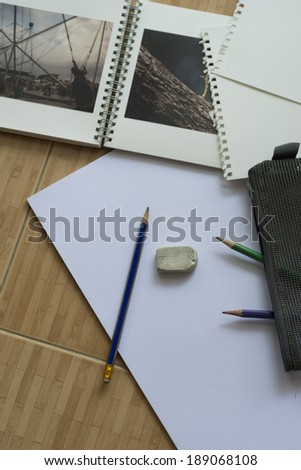 Blank paper,pencils,and sketch book on the wooden floor