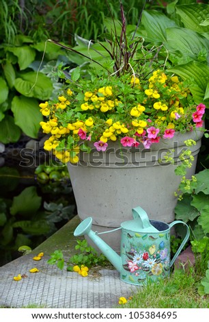 Colorful spring flower planter with decorative watering can