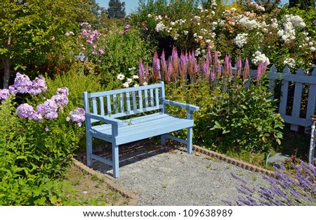 Blue wooden garden bench in summer garden