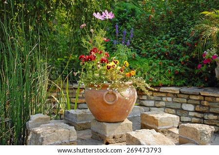 Brown ceramic planter filled with summer flowers