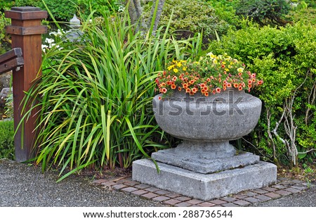 Stone garden flower planter filled with colorful plants