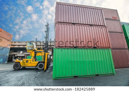 Crane lifter handling container box loading to truck in import export logistic zone