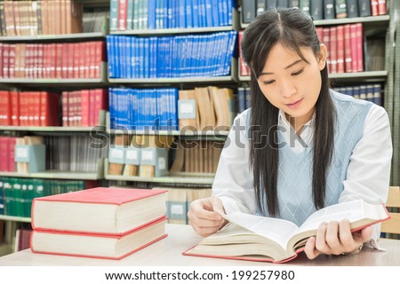 Asian student reading book in library at university