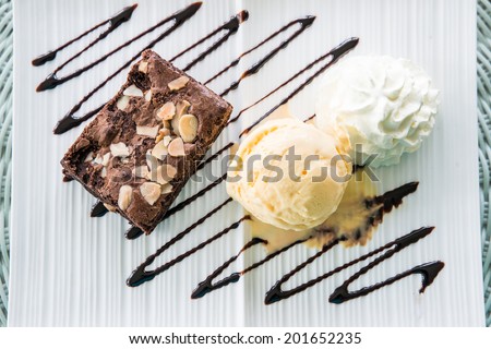 Vanilla ice cream Brownie and whipping cream in dish on table