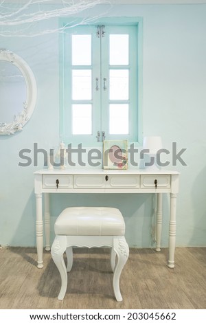 White wooden vanity table with window in background