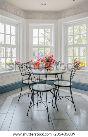 Vase of flower on table with windowsill in background