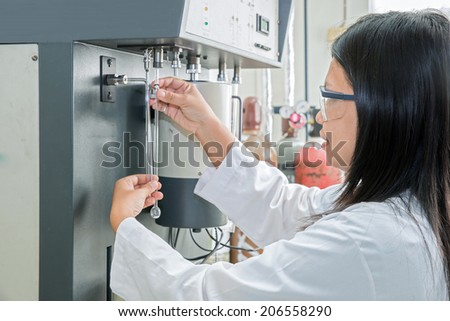 Scientist using chemical machine(autosorb) in laboratory