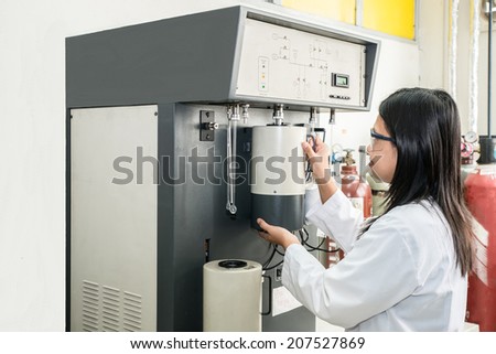 Chemical scientist using machine(autosorb) in laboratory