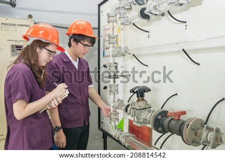 Chemical engineer student checking equipment in control room for training