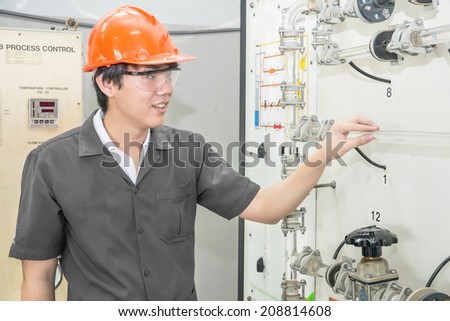 Chemical engineer checking part of machine in factory