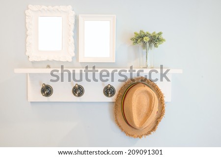 Hat hang on the  wall with picture frames