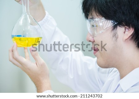Asian cientific researcher looking closely at the result of the experiment