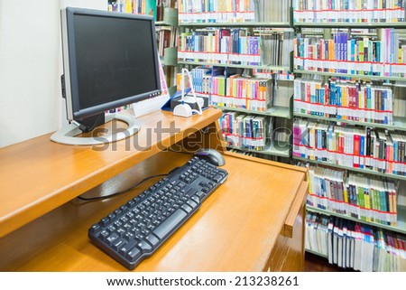 computer in a library with many books and shelves in the background