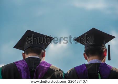 Back of graduates with blue sky