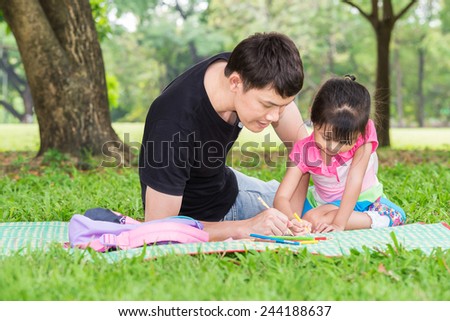 Happy kid and dad paint together in park