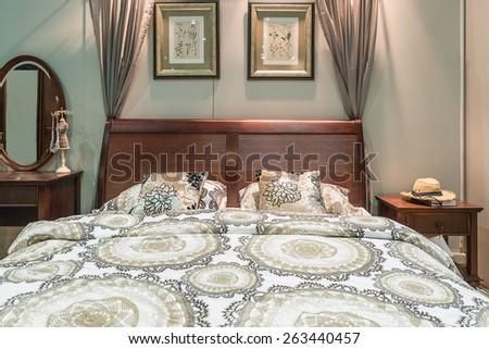 Luxury bedroom furniture. Carved wood bed with pillows and lamps on nightstands