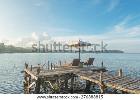 Summer, Travel, Vacation and Holiday concept - Beach chairs and umbrella on wooden desk against blue sky in Phuket,Thailand