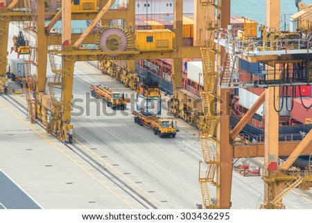 Container Cargo freight ship with working crane loading bridge in shipyard at dusk for Logistic Import Export background