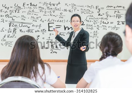 Asian teacher with a group of high school students in classroom