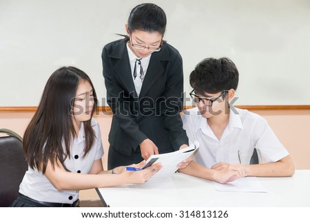 Couple asian student in uniform with a teacher in classroom