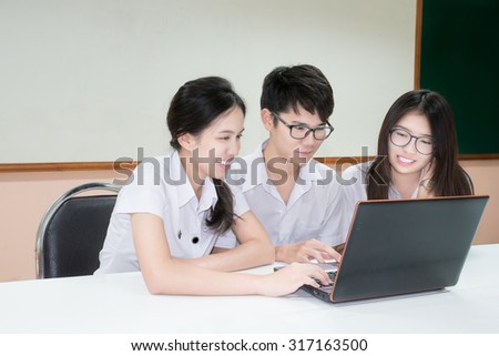 Group of Asian student in uniform E-learning through Laptop in classroom