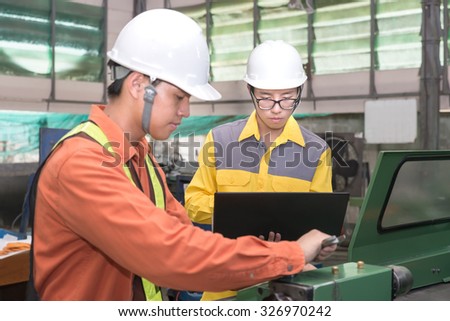Asian Mechanical Engineer using computer-aided to do planning and control equipment in factory