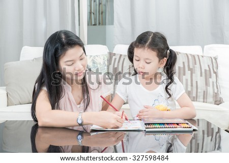 family, children and happy people concept - mother and daughter drawing at home