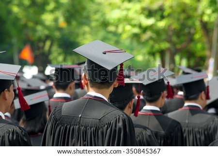 Back of graduates during commencement at university. Close up at graduate cap
