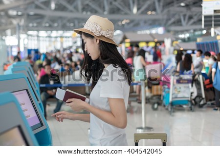 Traveler in Airport - Young Asian woman using self check-in kiosks in airport. Traveler using technology in airport