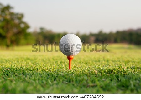 Golf ball on a tee against the golf course