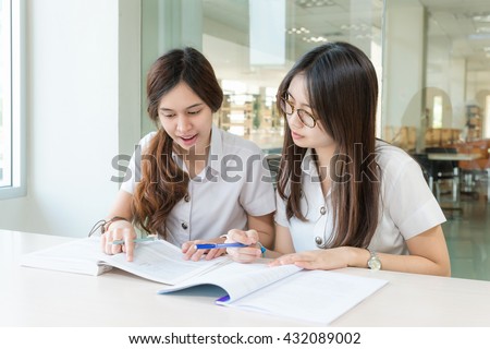 Two Asian students studying together at university.
