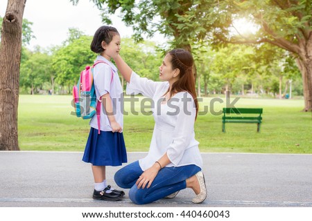 Back to school. Happy Asian mother with kids student in school. Asian mother adjusting kids student shirt in school.
