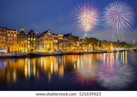 Night Amsterdam city view of Netherlands traditional houses with new year fireworks in Amsterdam, Netherlands