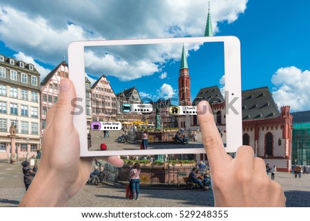 Hand holding smart phone use AR application to check relevant information about the spaces around customer. Frankfurt City in background. Augmented reality marketing concept