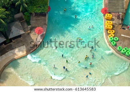 Top view of water park with many traveler have fun swimming pool in Sentosa, Singapore.