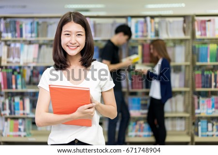 Group of Asian students studying together in library at university. University students