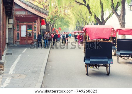 Tourists riding Beijing traditional rickshaw in old China Hutongs in Beijing, China.