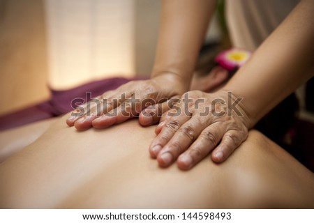A woman performs a Thai back massage