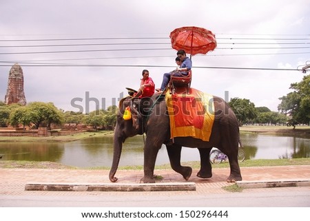 AYUTTHAYA, THAILAND - AUGUST 10 : Tourist group rides on the backs of elephants visit the ancient city of Ayutthaya on August 10,2013 in Ayutthaya,Thailand.
