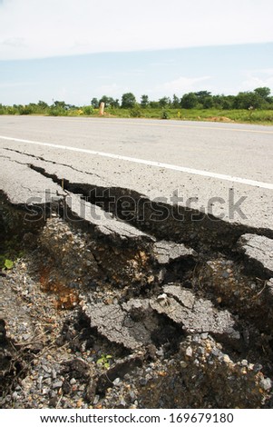 cracked asphalt road after flood ,damaged roadway
