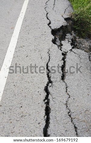 cracked asphalt road after flood ,damaged roadway