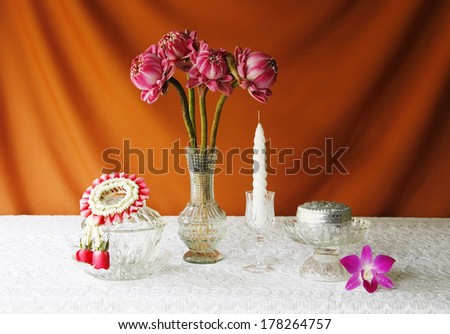 still life with glass bowl,vase,lotus,silver bowl,glass tray with pedestal,candle and jasmine garlands