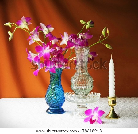 still life with glass,vase,orchid,glass tray with pedestal and candle.
