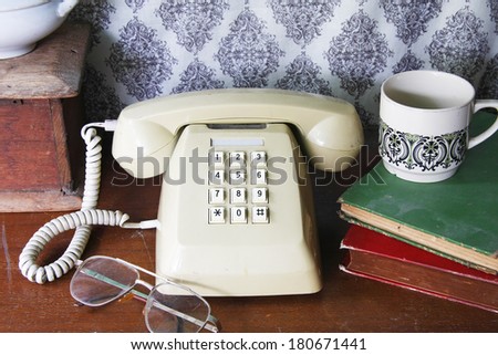 still life with old book,glasses,Push Button Telephone and coffee cup on wooden table.